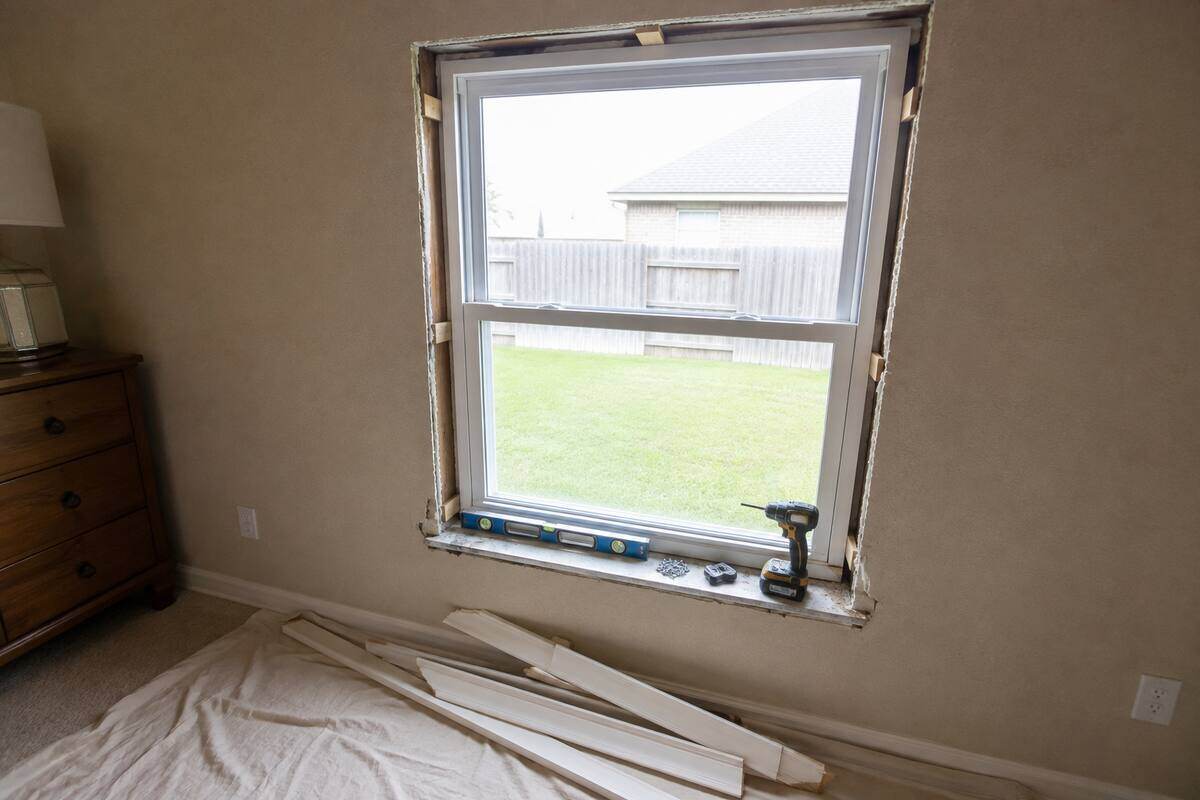 Window set in a framed opening and shimmed